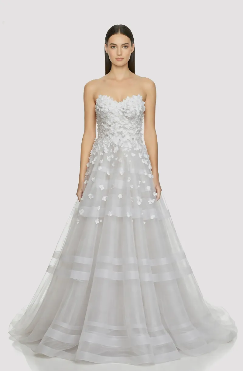 Front view of a woman in an Off-white tulle ball gown with cascading 3D flowers on the bodice and concentric horsehair accents on the skirt 5, image 1