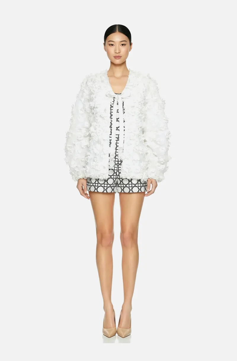 Front view of a woman in a Sheer white georgette overblouse with 3D floral appliqués, voluminous sleeves, and a front tie closure 55, image 1